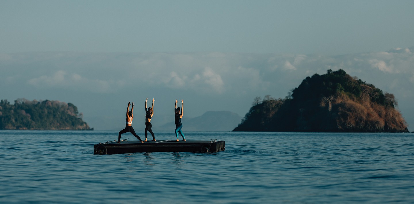 Two women take a private yoga class on a floating ocean platform at the Islas Secas resort | Islas Secasn