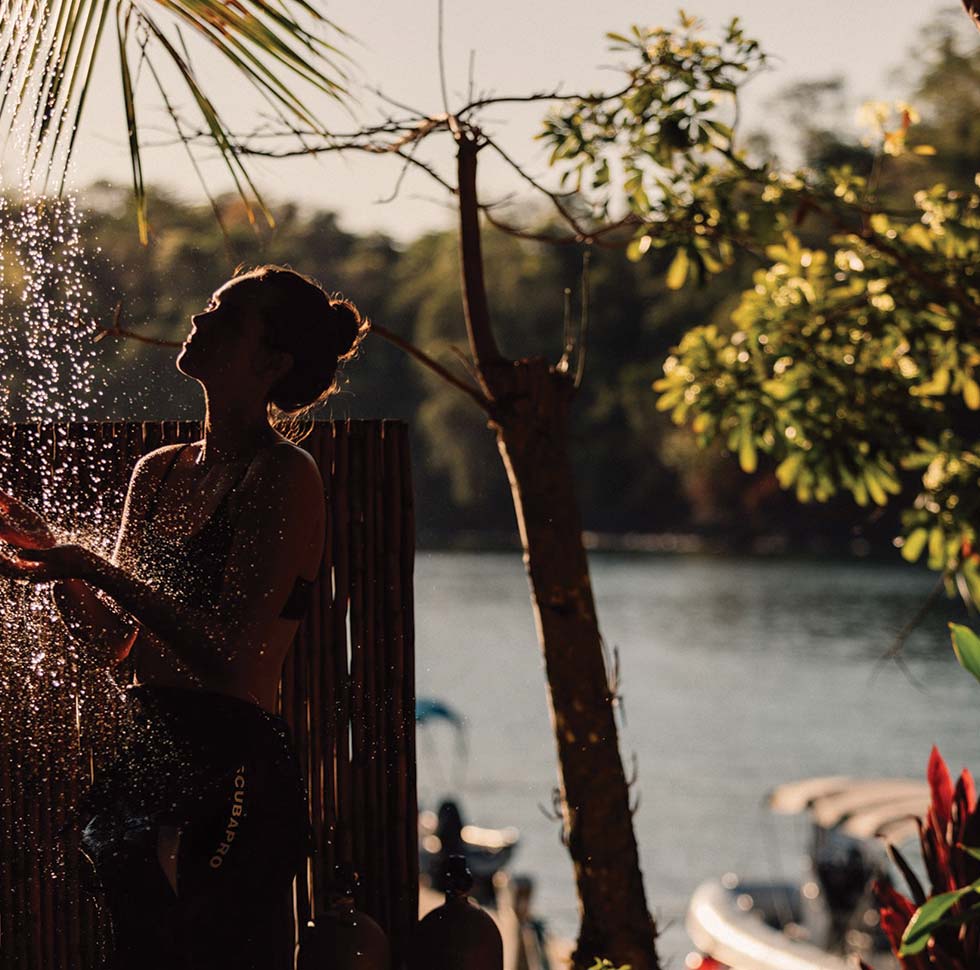 A guest enjoys an outdoor shower to cool off at the Islas Secas resort | Islas Secas