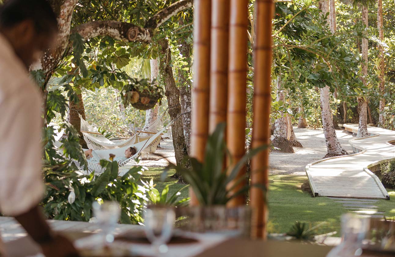 A female guest reclines in a hammock on the beach outside La Terraza shaded by the trees that ensure privacy | Islas Secas